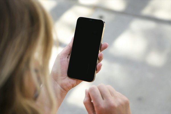 スマートフォンを手に持つ女性(オンライン診療のイメージ)