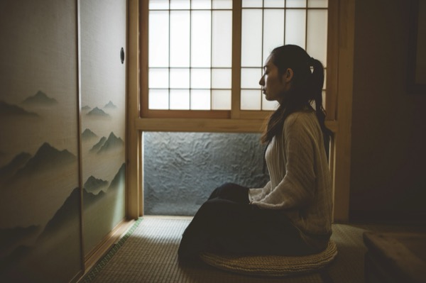 障子窓のそばで静かに座る女性